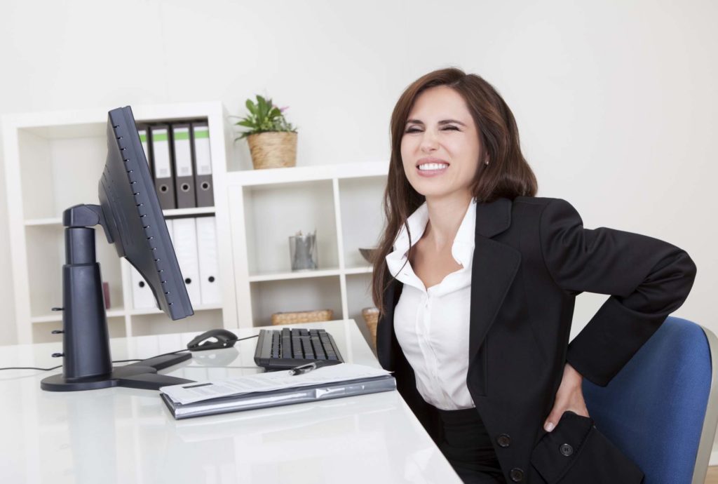 soulager le mal de dos par le sport jeune femme qui a mal au dos au bureau