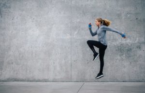 femme en cours d echauffement pour la course a pieds en faisant des montees de genoux